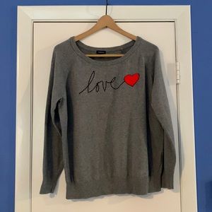 Grey crew neck sweater with the word “Love” on it and a red heart